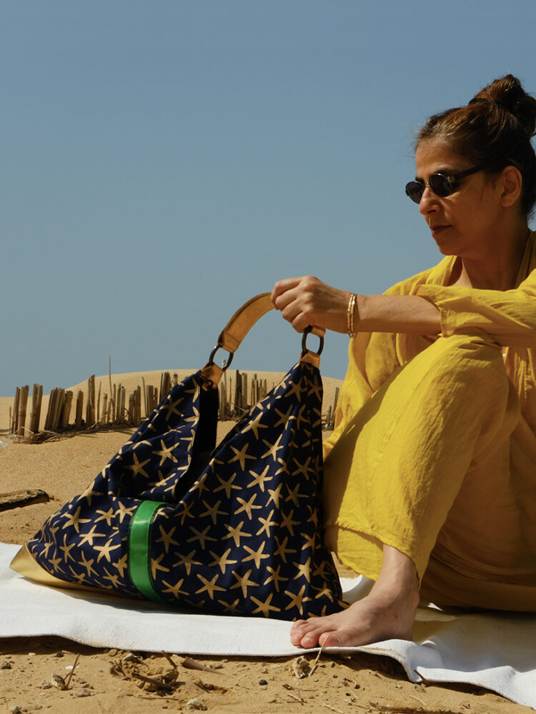 The Night Nut handbag combines genuine leather and Pharaonic-inspired cotton print. The golden stars print on the navy blue complement the gold leather,